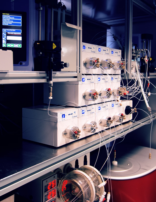 Der Radial-Synthese-Automat: Mehrere weiße Kästchen, die mit vielen dünnen Kabeln verbunden sind. 